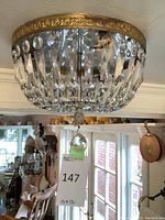 View of chandelier from below showing gold-tone metal frame and faceted crystal prisms