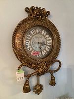Full view of ornate gold-tone pendulum clock on wall