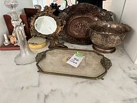 Overall view of mirror, platter, bowl, decorative tray and additional items on shelf
