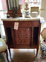 Front view showing marble top, single drawer and cabinet door with inlay