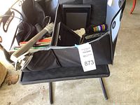 Black collapsible organizer placed on small black plastic folding table containing various items
