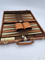 Backgammon set open showing playing surface, checkers, dice, and dice cups.