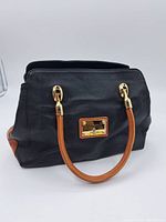Black and brown leather ladies' handbag with gold hardware and Valentina Italia metal logo plate.