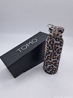 Photo of Tomo water bottle with sequin leopard print cover and original black box