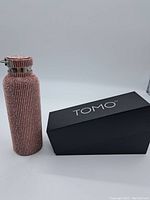 Full view of the pink rhinestone-covered TOMO stainless steel water bottle with accompanying black TOMO box.