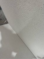 Close-up image showing the white smooth texture of one Armstrong Oasis ceiling tile.