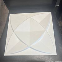 Single white decorative 3D wall panel showing geometric textured pattern.