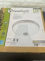Box packaging showing the Good Earth Lighting brand, Legacy series, 15 inch size, LED light information, and energy savings details.