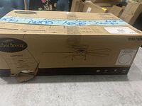 Closed cardboard box showing Harbor Breeze Armitage 52-inch ceiling fan with some box damage.