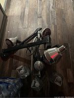 Top view of Medusa infrared hair color processor showing multiple adjustable arms with silver bulb housings lying on wooden floor.
