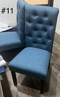 Two tufted Parsons dining chairs in blue fabric showing front and side view, highlighting button tufting and padded seats.