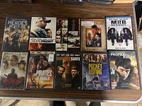 Photo showing front covers of 10 DVD movies: Heroes Never Die, Homefront, Across the Line, Men in Black II, Rain and Lightning, The Pirates of Somalia, The Saints, Pocket Listing, Profile of a Killer, and Boondock Saints II.