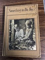 Front cover of the antique book showing the title "Something-to-Do, Boys" and a black and white photo of two boys playing.