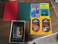 Full view of the seven Dell Shannon books showing the front covers and two hardcovers with colored boards