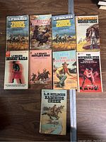 Nine vintage L.P. Holmes Western paperback books laid out showing front covers