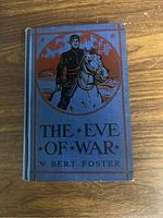 Front cover of blue hardcover book 'The Eve of War' showing soldier and horse illustration in red and black.