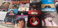 21 vintage vinyl records showing various album covers including country, pop and tango music genres. Covers show some age and wear.