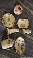 All seven Japanese porcelain pieces arranged on fabric background