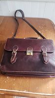 Front view of Bosca brown leather briefcase with visible buckles and lock mechanism, showing original condition.