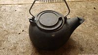 Top view of the cast iron kettle showing the flat lid and spring coil handle attachment points.