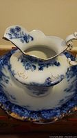 Close up of pitcher spout showing blue floral patterns and gold trim