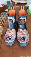 Front-top view of pair of Joules Original Wellibob rain boots showing floral pattern and orange interior lining.