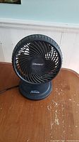 Front view of Sunbeam Blizzard fan showing grille, logo, and adjustable tilt base