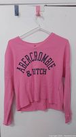 Front view of pink long-sleeve Abercrombie & Fitch shirt showing logo and overall condition.