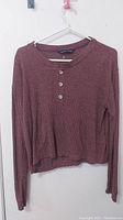 Front view of the women's long sleeve knit sweater in reddish-brown with 3 buttons at the chest.