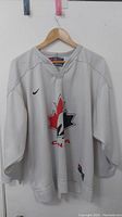 Front view of the white Nike Canada hockey jersey showing logo and design details.