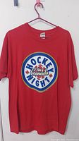 Front view of the red T-shirt showing the Hockey Night in Canada logo.