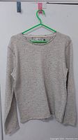 Full view of the beige Jack and Jones Originals women's sweater hanging on a green hanger.