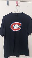 Front view of navy blue Montreal Canadiens T-shirt with logo on front