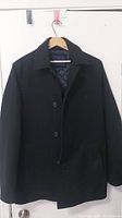 Front view of black Tommy Hilfiger men's jacket showing button closure and collar
