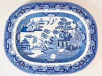 Full top view of large oval Blue Willow platter showing detailed scenic pattern in blue and white with decorative border.