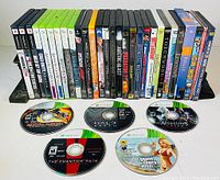 Front view of 26 assorted video game cases, arranged side by side showing titles for Xbox, PlayStation 2 and PlayStation games