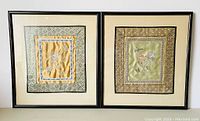 Pair of rectangular black-framed silk tapestries with flower and butterfly embroidery hung side by side.