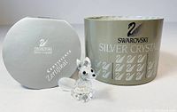 Photo of Swarovski crystal fox figurine next to the original box and certificate booklet