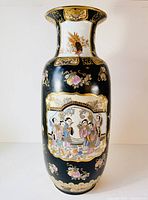 Front view showing detailed story scene with figures and gold accents on a black background.