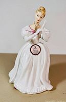 Full view of the Royal Doulton figurine showing the white dress and pink detailing.