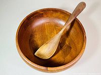 Wooden salad bowl with wooden spoon inside, showing bowl depth and grain pattern