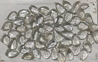 Forty-seven clear faceted antique chandelier drops, teardrop shape, with metal hooks for hanging.