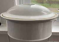 Front view of white ceramic covered dish with lid, showing round shape and smooth finish