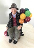 Front view of the Royal Doulton Balloon Man ceramic figurine with colorful balloons on his back.