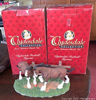 Two original red boxes of The Clydesdale Collection by Anheuser Busch with Clydesdale Football Figurines displayed in front.