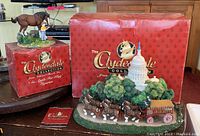 Photo of both figurines with their respective branded red boxes placed behind them.