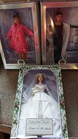 Three Barbie dolls displayed in original boxes with decorative backgrounds, featuring Elizabeth Taylor and Audrey Hepburn dolls.