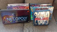 View of five boxed board games including Monopoly 2000, Powerpuff Girls, Net.Opoly, Looney Tunes, Pokemon-themed Monopoly games.