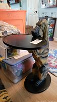 Side view of butler table with hound figurine base showing scratches and pet hair