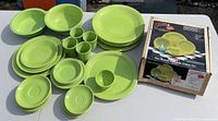 Full dinnerware set laid out including plates, bowls, mugs, saucers, and some boxed packaging